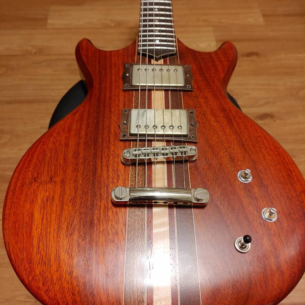 Padauk electric guitar body with maple center stripe and humbuckers