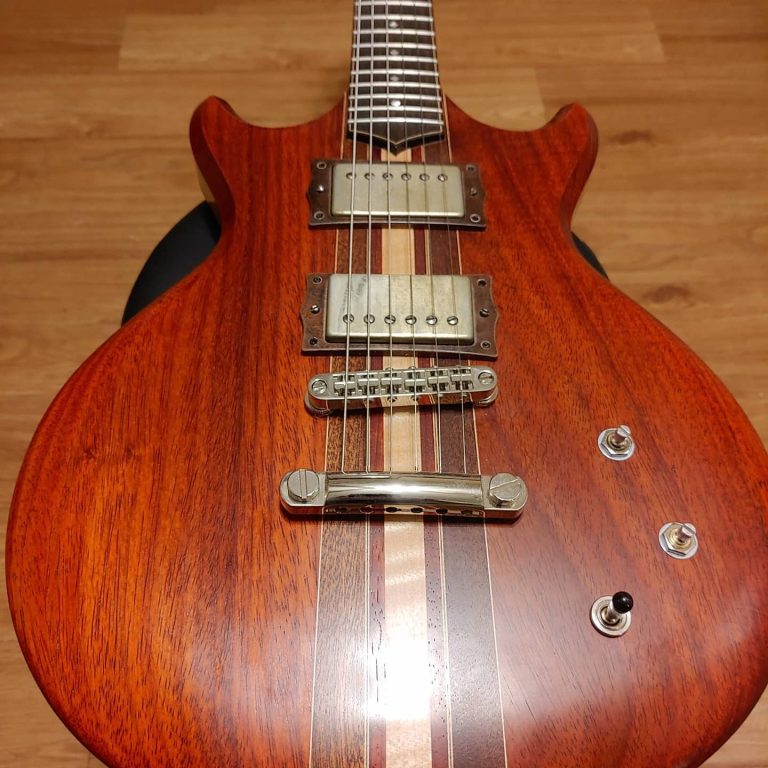 Padauk electric guitar body with maple center stripe and humbuckers