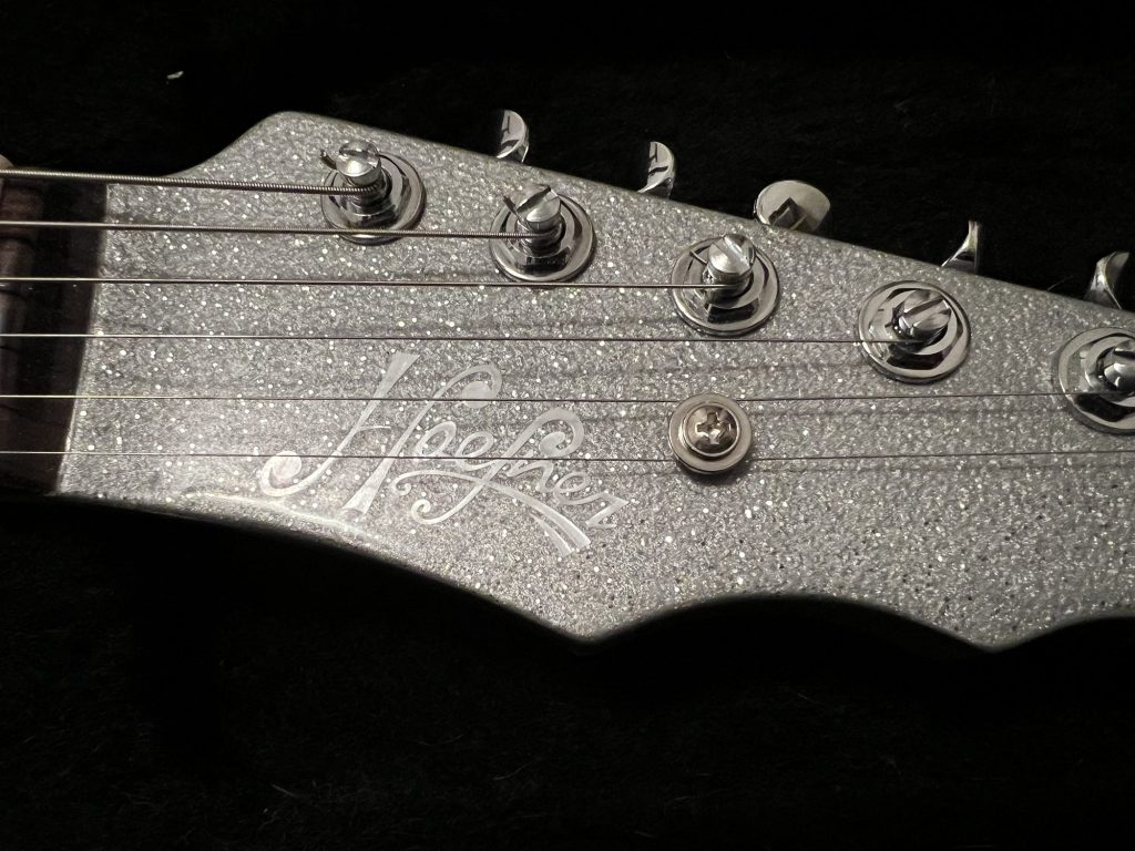 Silver sparkle electric guitar headstock